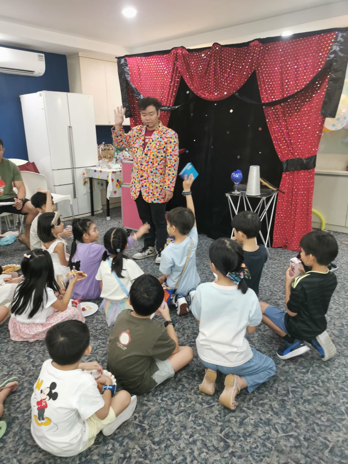 Children raising their hands to join an interactive magic show