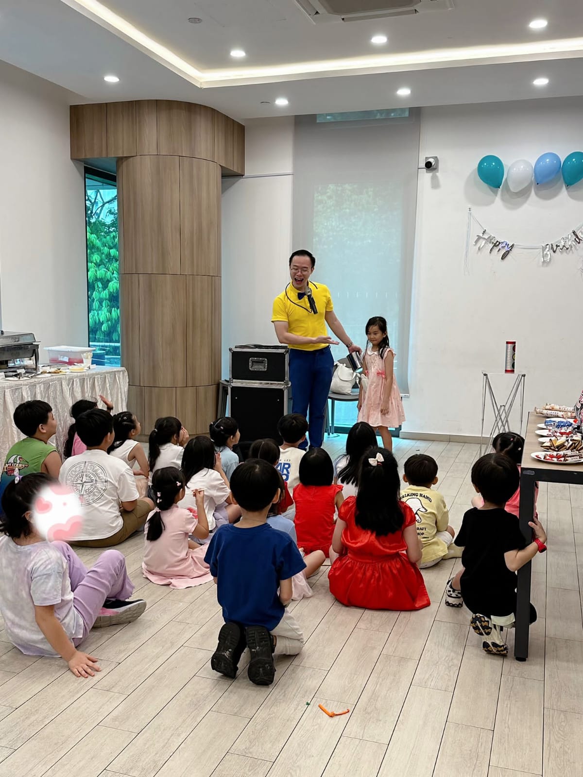 A child joining the magician while other children watch the magic show